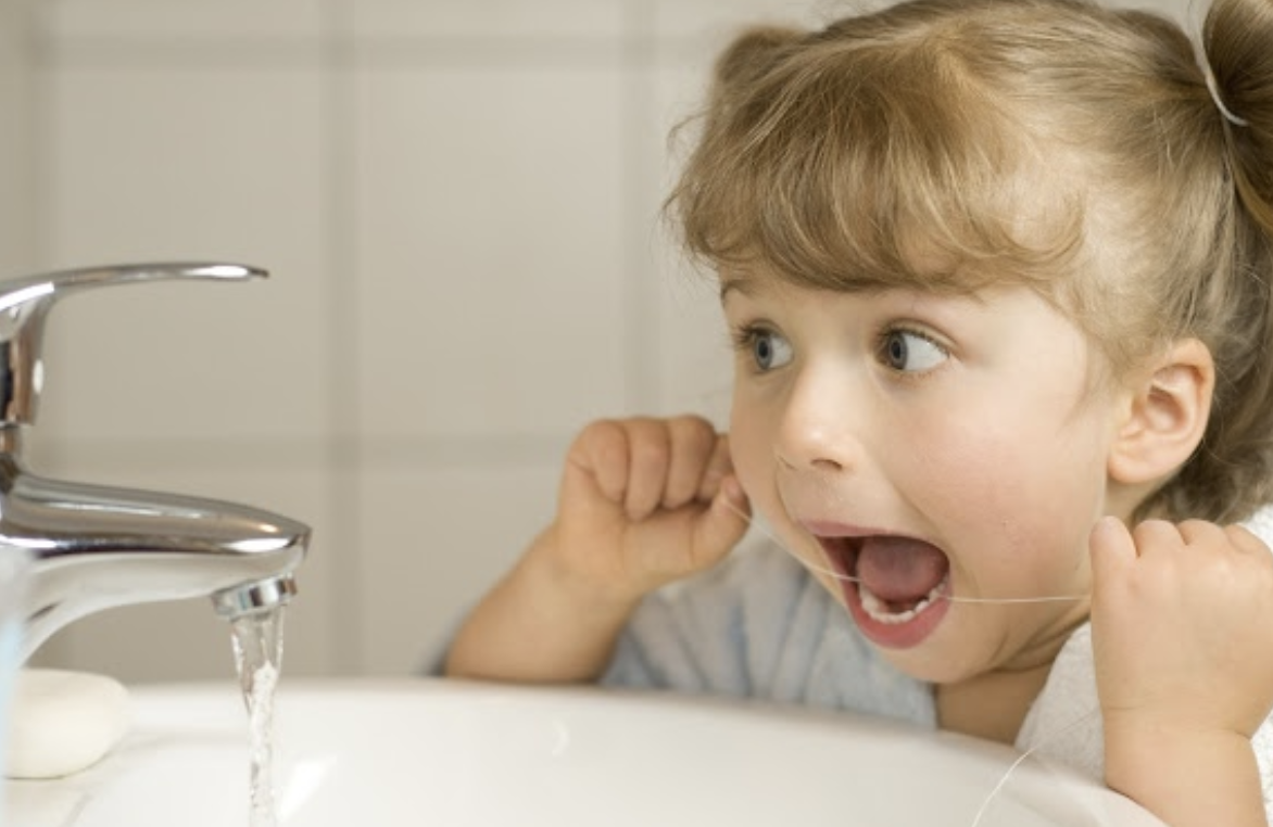 Little Girl Flossing Her Teeth